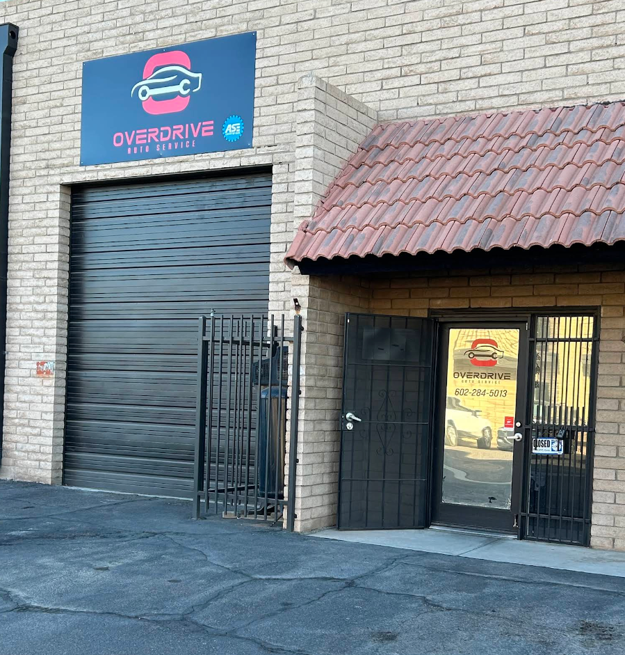 Brick storefront with a closed roll-up door, black entrance gate, and Overdrive sign above. | OverDrive Auto Service