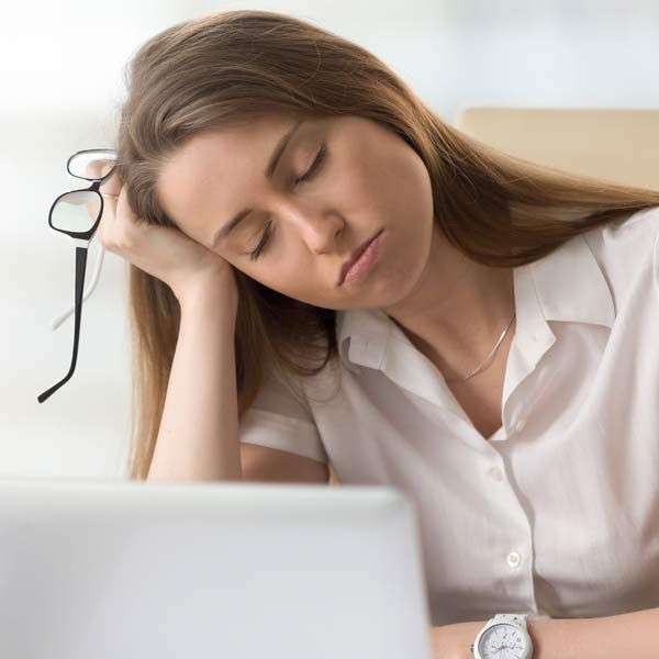 A woman with Chronic Fatigue is sleeping in front of a laptop computer