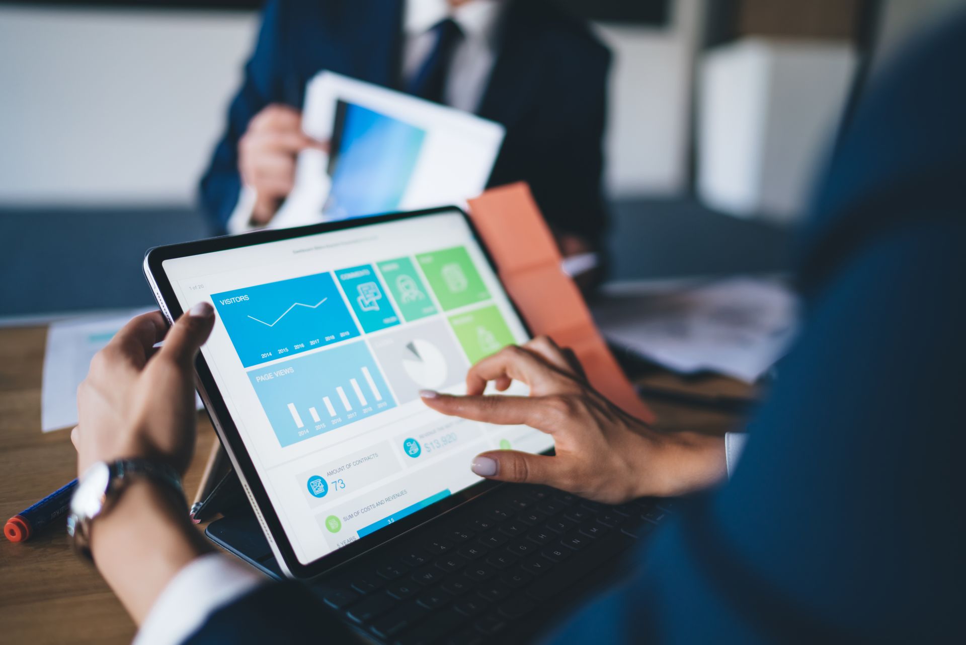 two people are looking at a tablet with a benefits administration platform dashboard on it