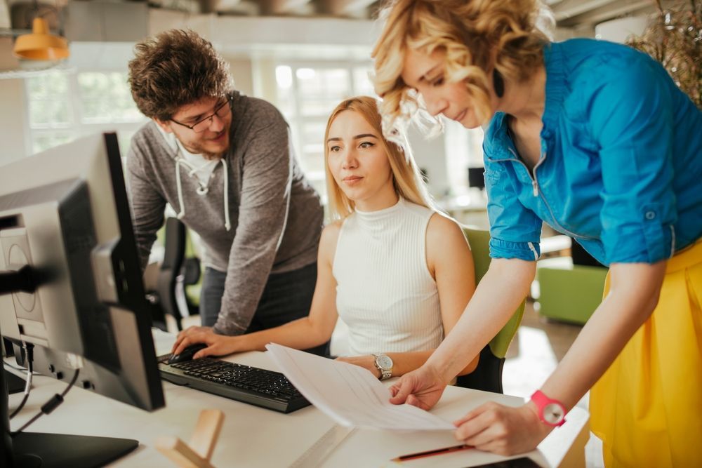 A group of people are looking at a computer screen.