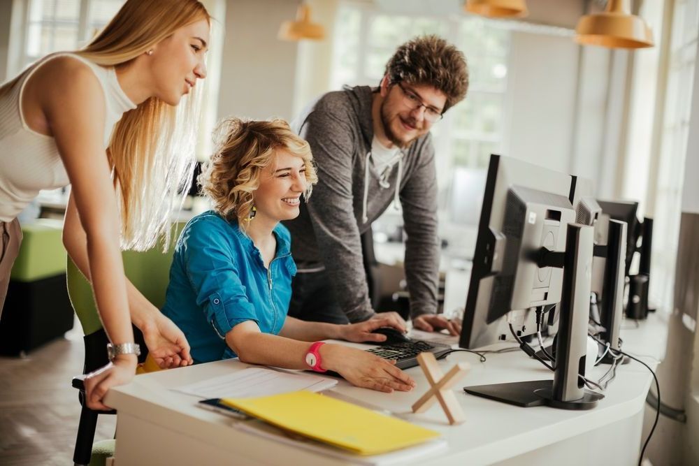 A group of people are looking at a computer screen.
