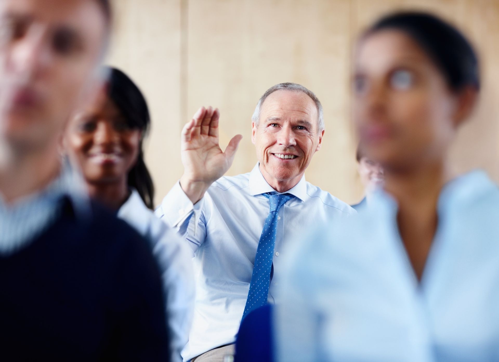 A man raising his hand to answer a question about key person insurance.