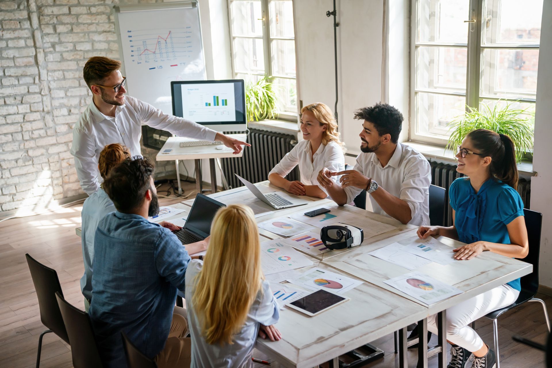 a group of people are sitting around a table having a meeting discussing employee benefits