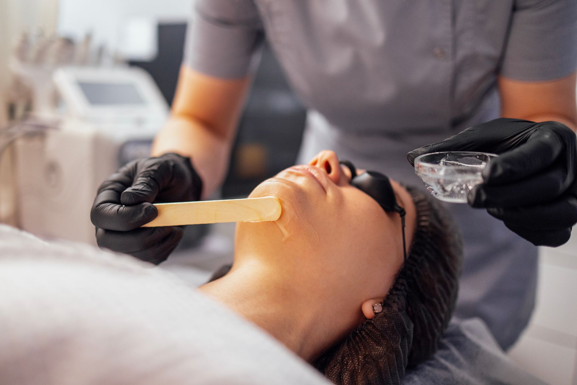 A woman is getting a facial treatment at a beauty salon.