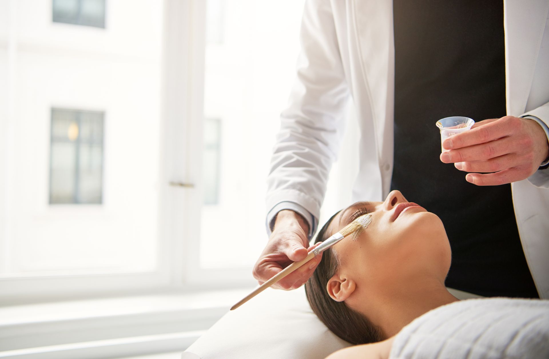 A woman is getting a facial treatment from a doctor.