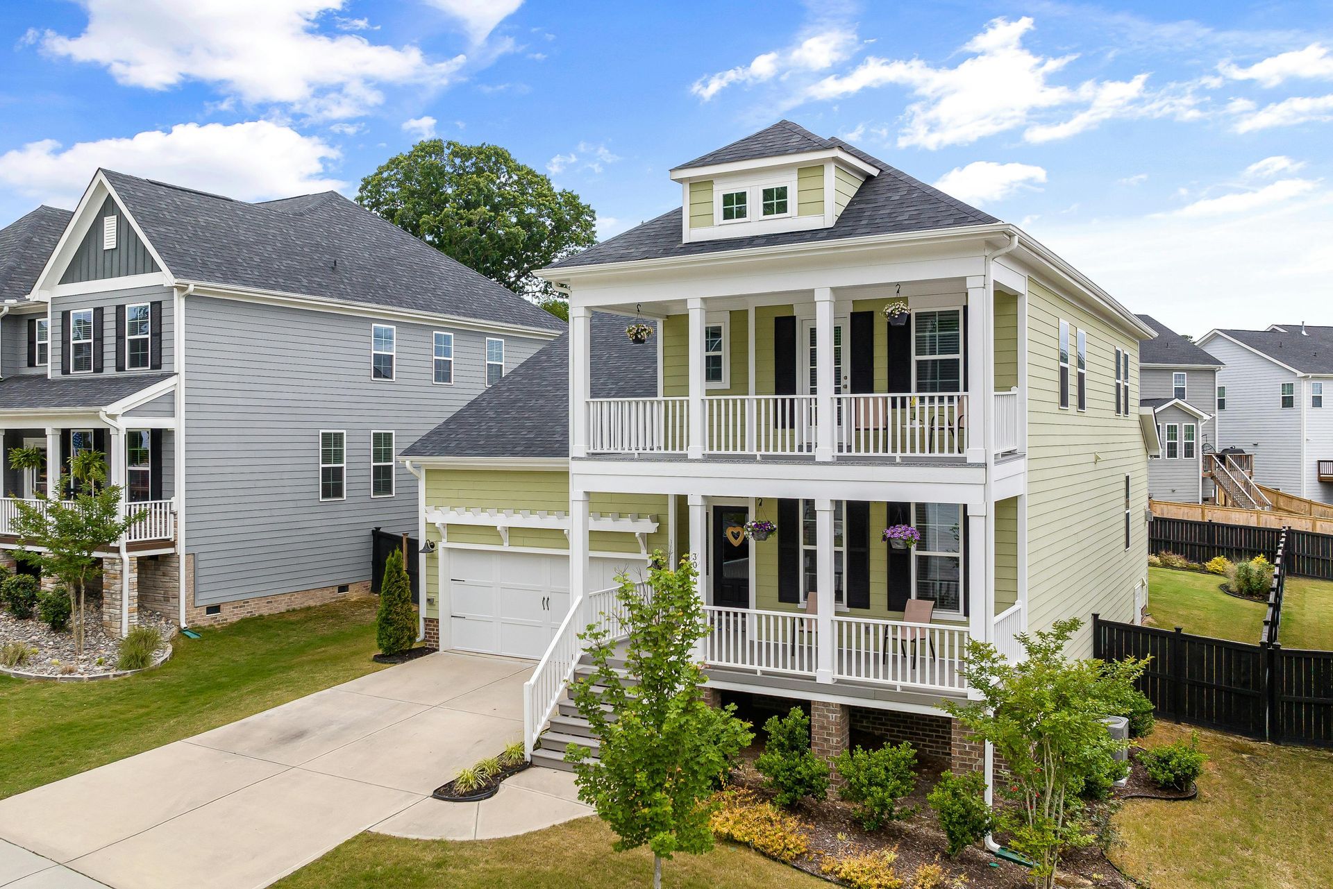 An aerial view of a house with a large porch in a residential area.