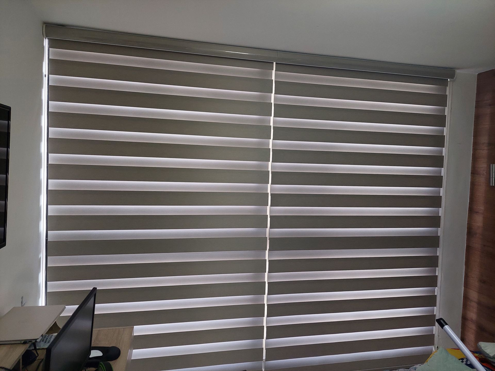 Una habitación con persianas cebra de doble panel