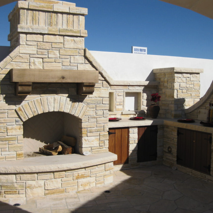 A stone fireplace with a chimney on top of it