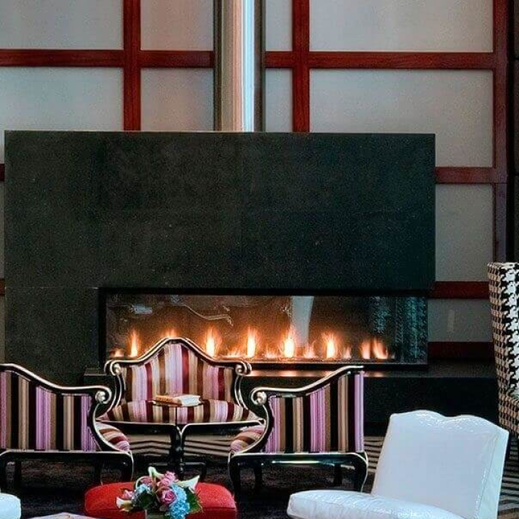 A living room with a fireplace and a striped couch