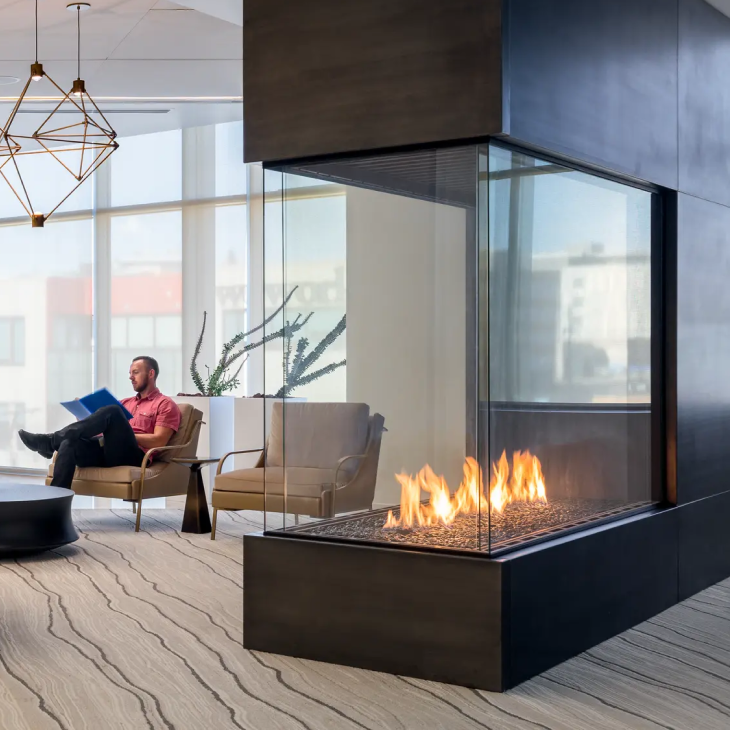 A man sits in a chair in front of a fireplace