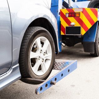 A car is being towed by a tow truck.