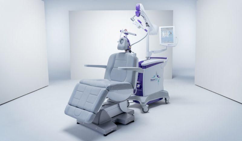 Medical chair with attached device; white and purple.