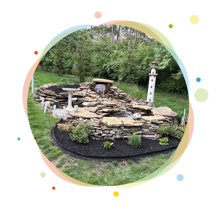 Landscaped rock waterfall with plants, lighthouse.