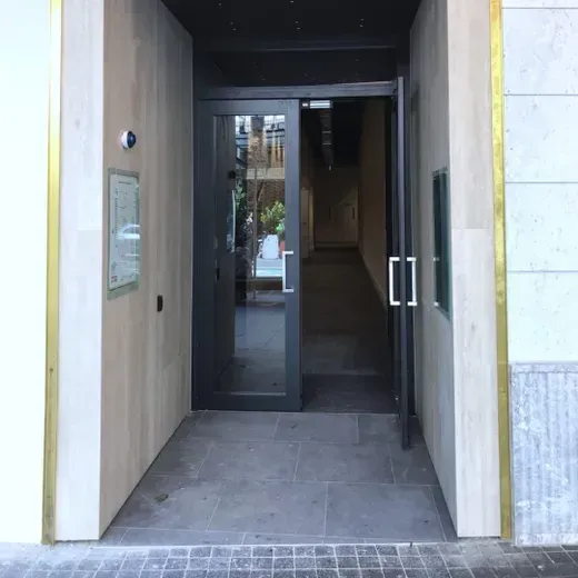 Building entrance with dark glass double doors and a narrow entryway corridor