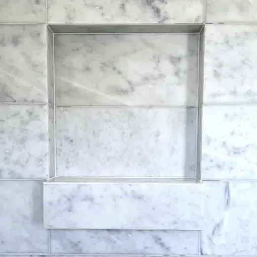 Marble-tiled wall with a recessed rectangular niche and a horizontal shelf-like ledge
