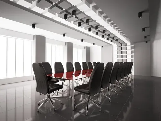 Modern conference room with black chairs around a glossy red table and large windows
