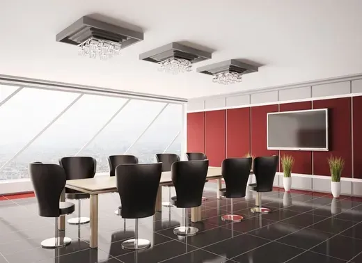 Modern conference room with black chairs, white table, red wall panels, and wall-mounted screens