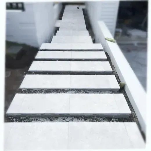 Factory conveyor carrying white rectangular slabs through a production line