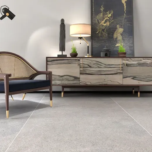 Modern living room with a wicker chair, marble console, wall art, lamp, and gray tile floor