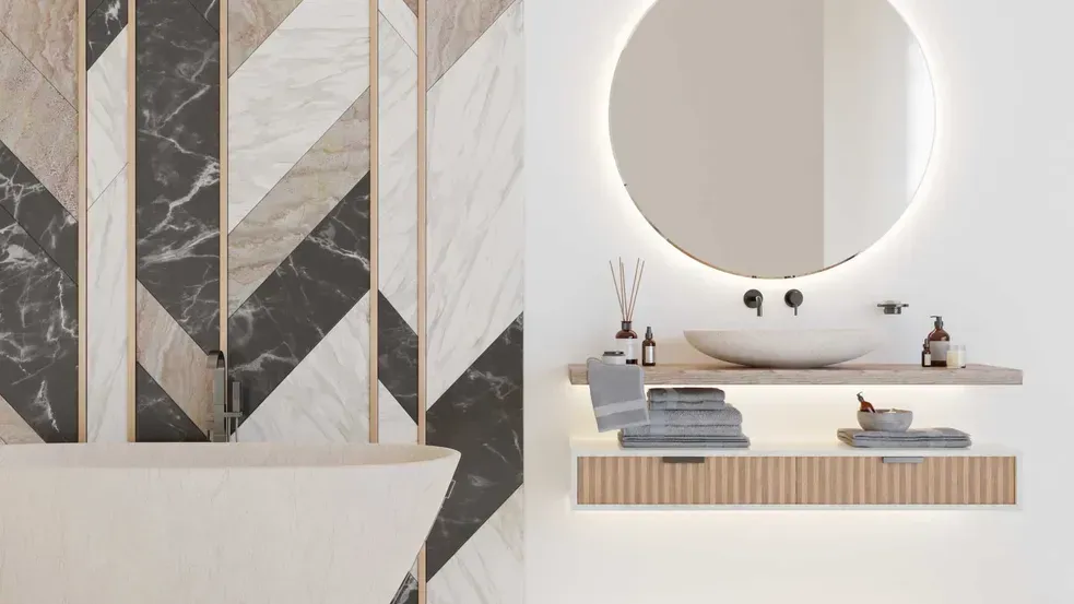 Modern bathroom with marble wall panels, round backlit mirror, floating wood vanity, and neatly stacked towels