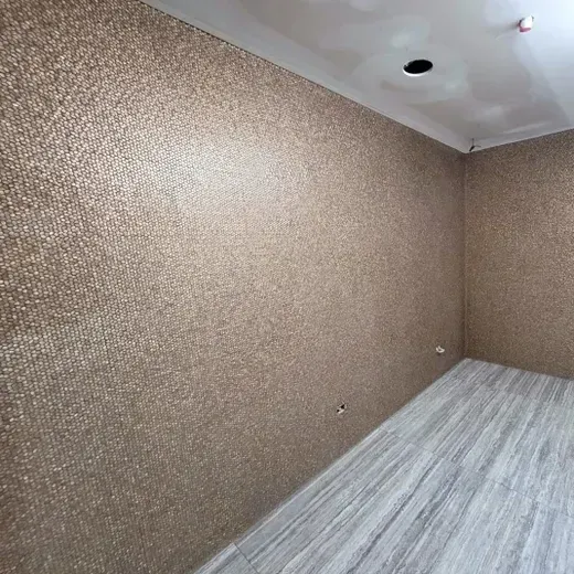 Empty room with brown textured walls, gray wood floor, and a ceiling light opening