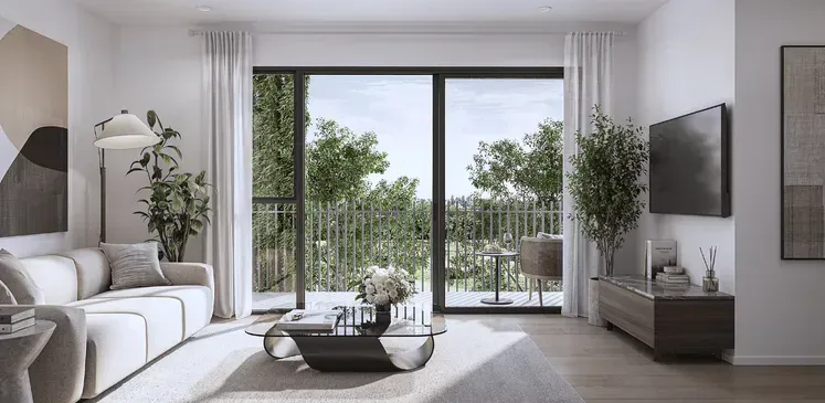 Modern living room with white sofas, coffee table, wall TV, and large glass doors opening to a balcony with greenery