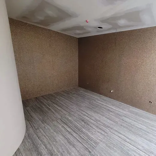 Empty room with brown walls, gray flooring, and a white column on the left.