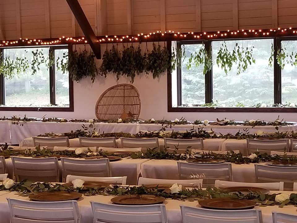 A large room with tables and chairs set up for a wedding.