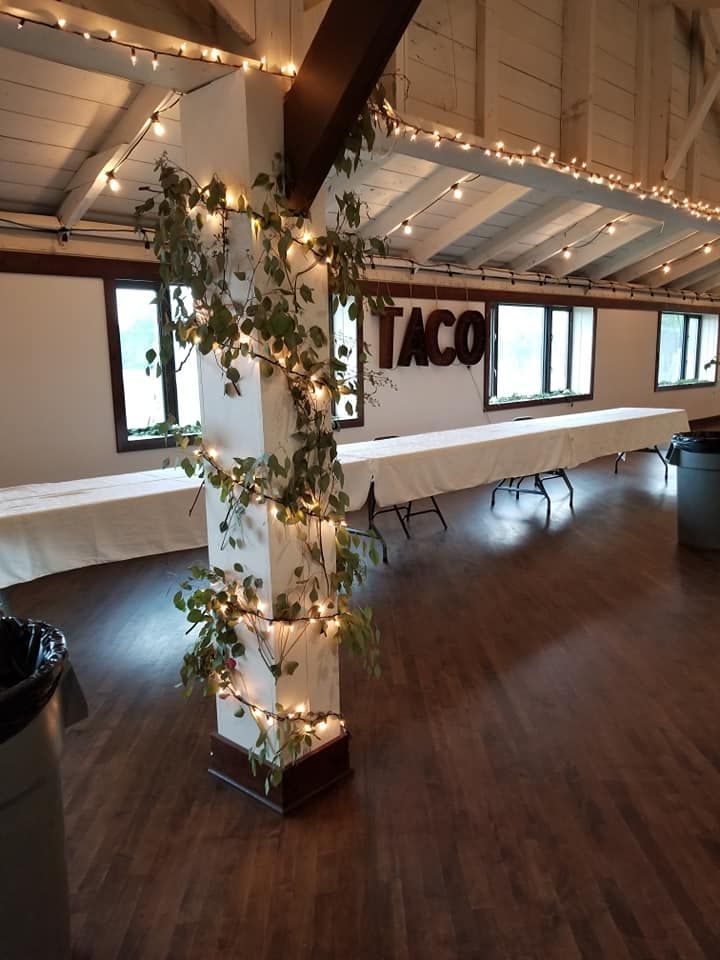 A room with tables and a sign that says taco on the wall.