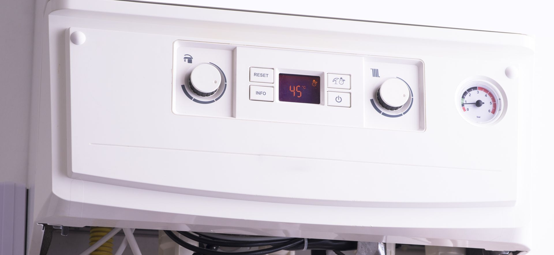 White boiler with controls and pressure gauge.
