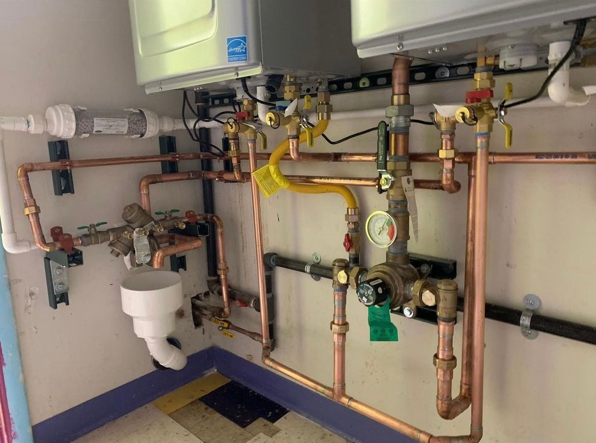 A room with a lot of pipes and a sink.