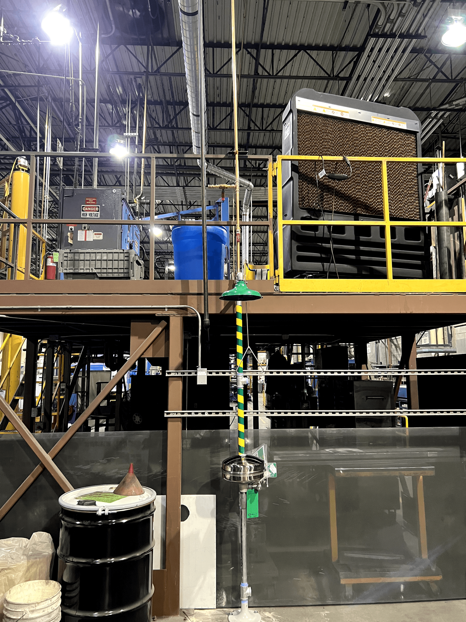 A warehouse with a yellow railing and a green hose