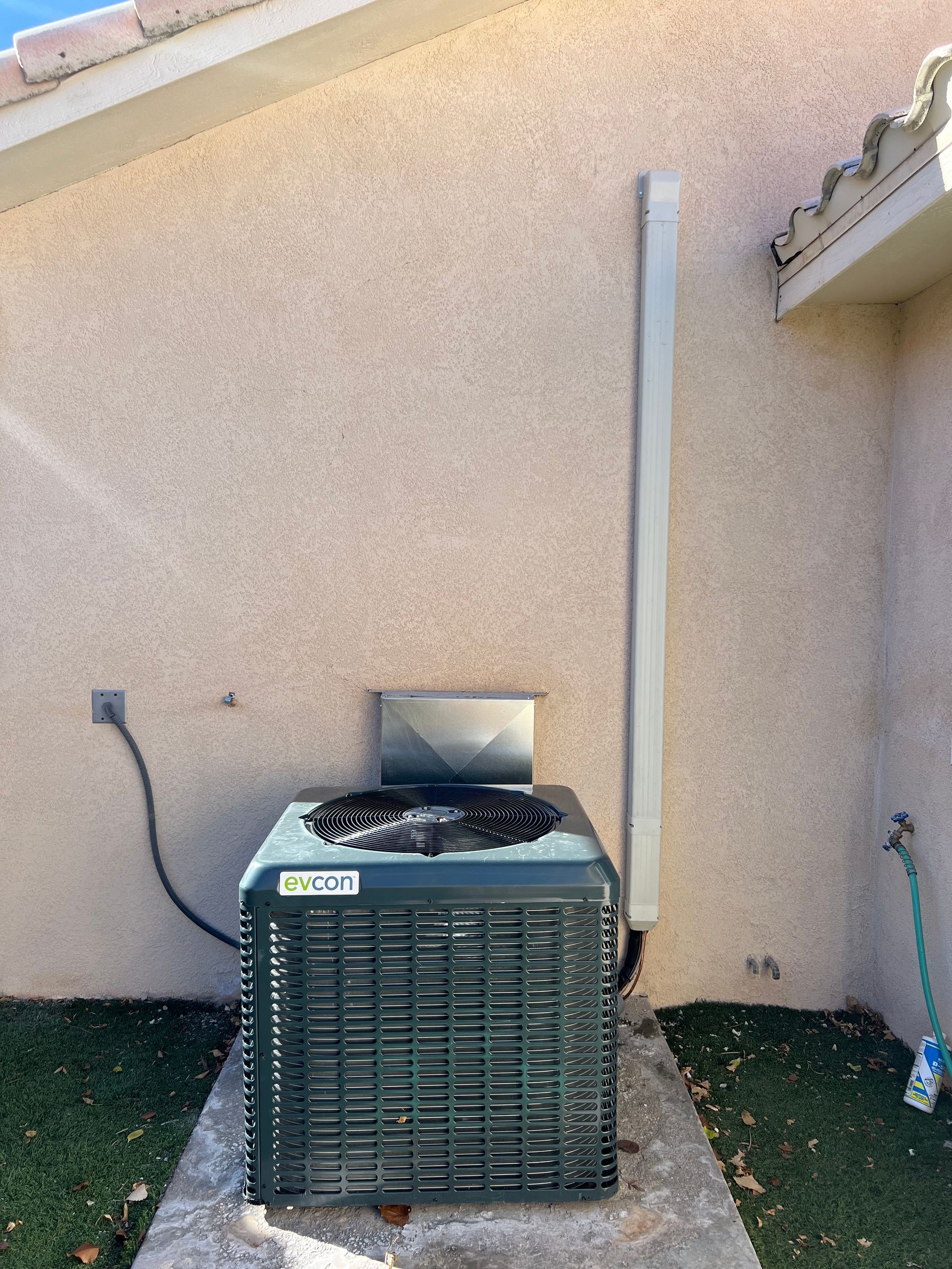 An air conditioner is sitting on the side of a building.