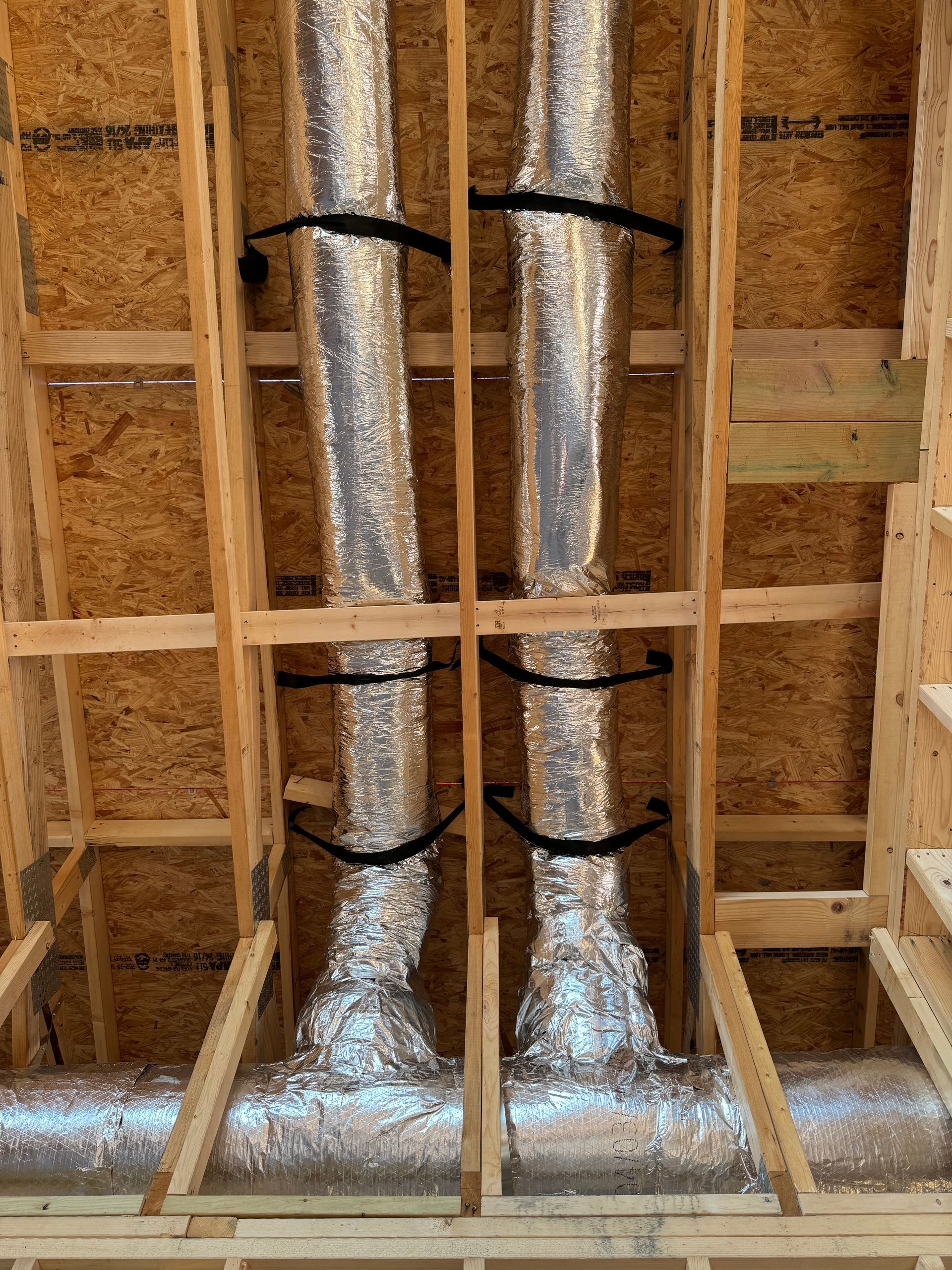 A bunch of pipes are hanging from the ceiling of a building.