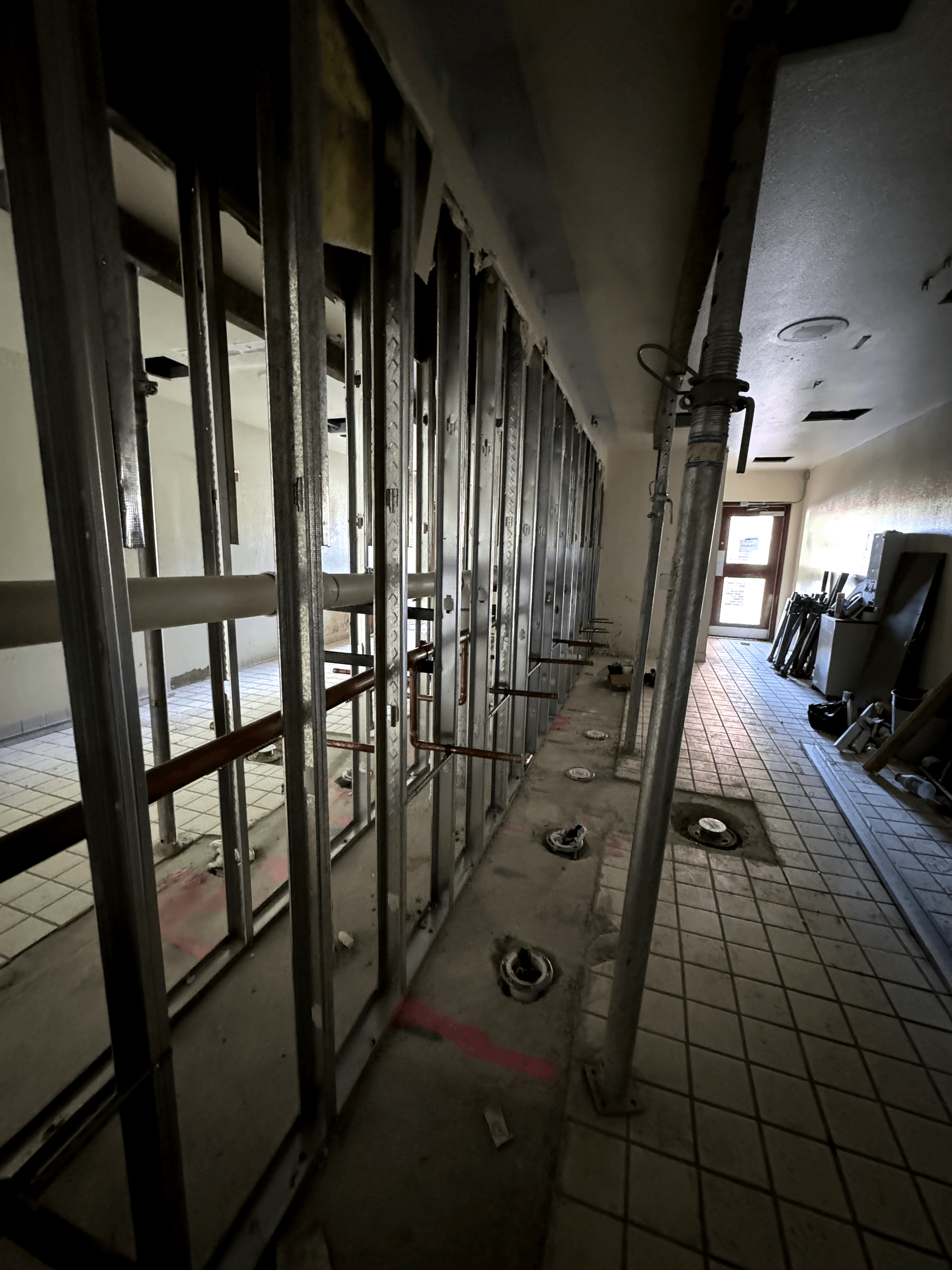 A hallway with a lot of metal walls and a tiled floor