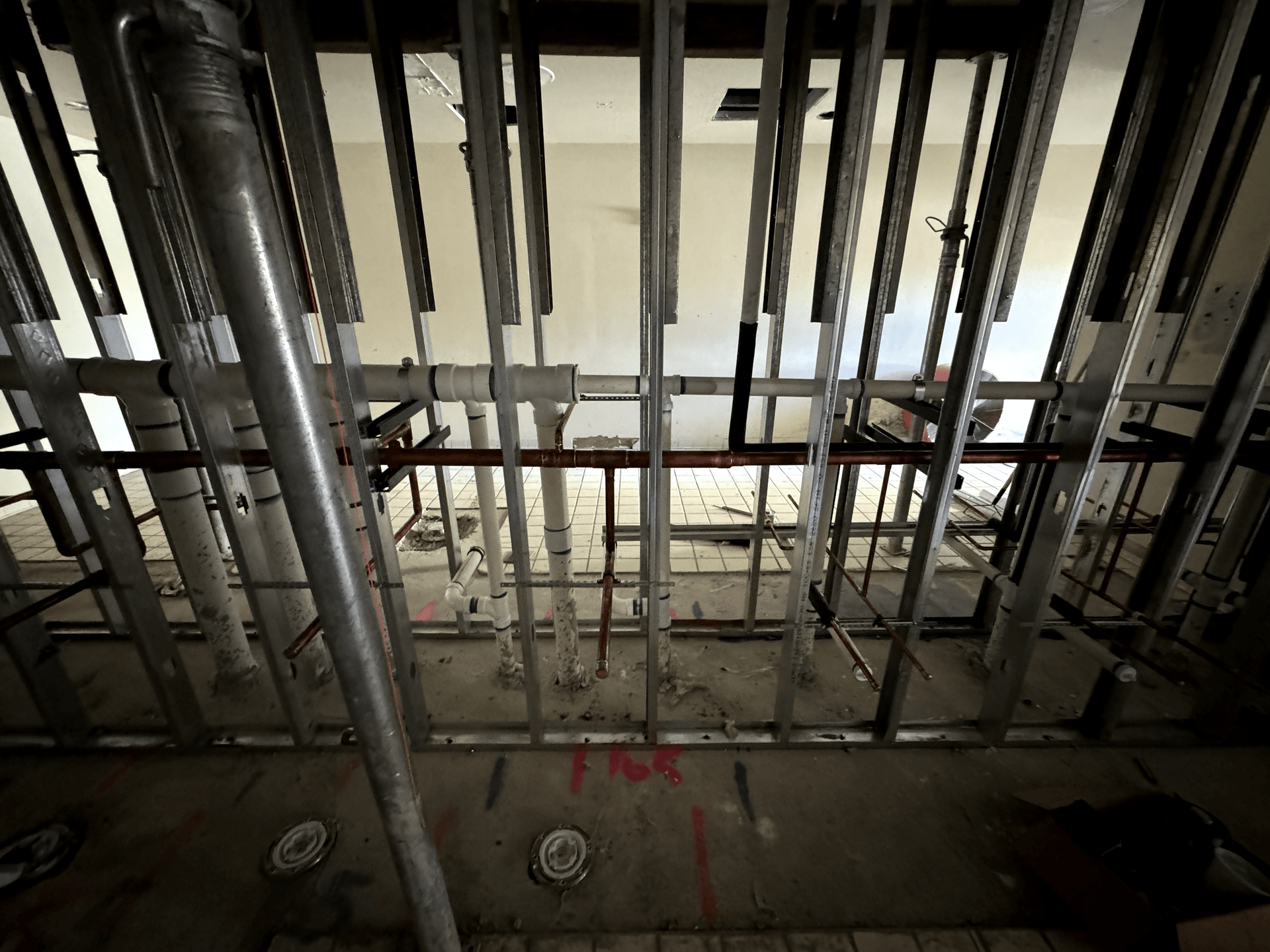 A bunch of pipes are hanging from the ceiling of a building.