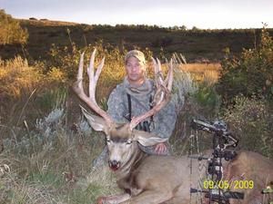 Hunter with camo gear poses with a large buck, bow in the foreground, taken on Sept. 5, 2009.