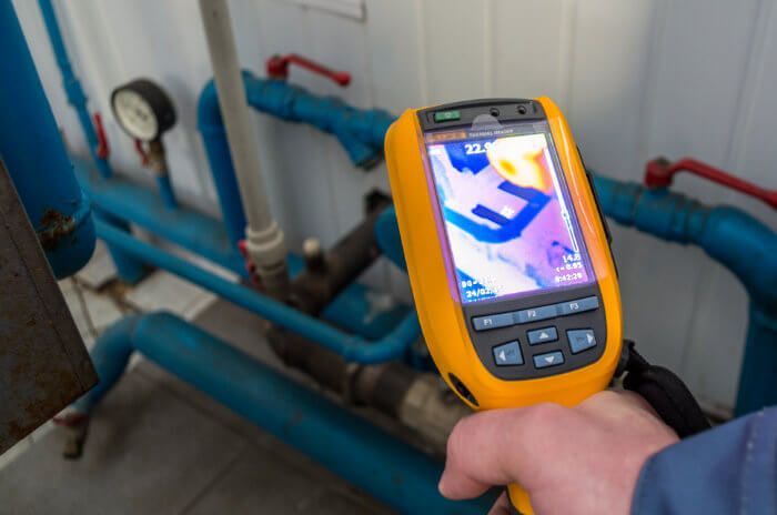 A person is holding a thermal camera in their hand.