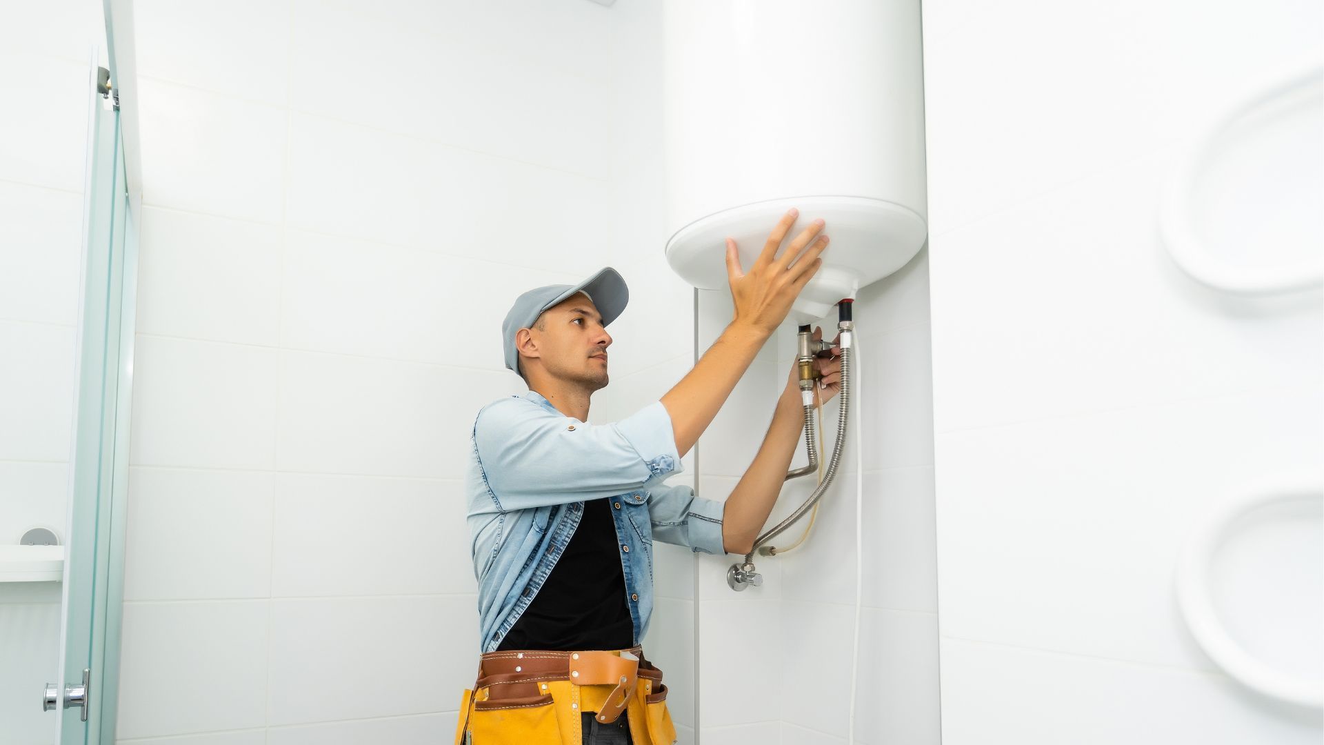 Two men are working on a drain in a kitchen.
