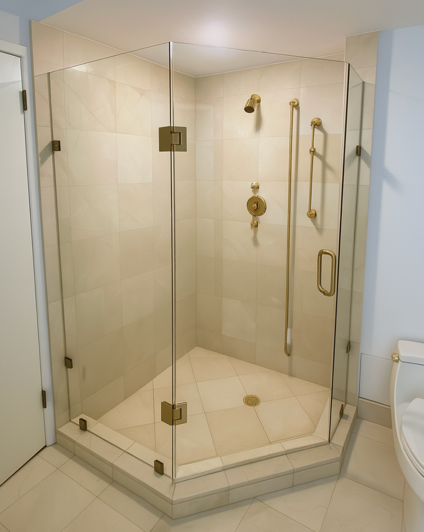 Corner shower stall with glass doors and brass fixtures.
