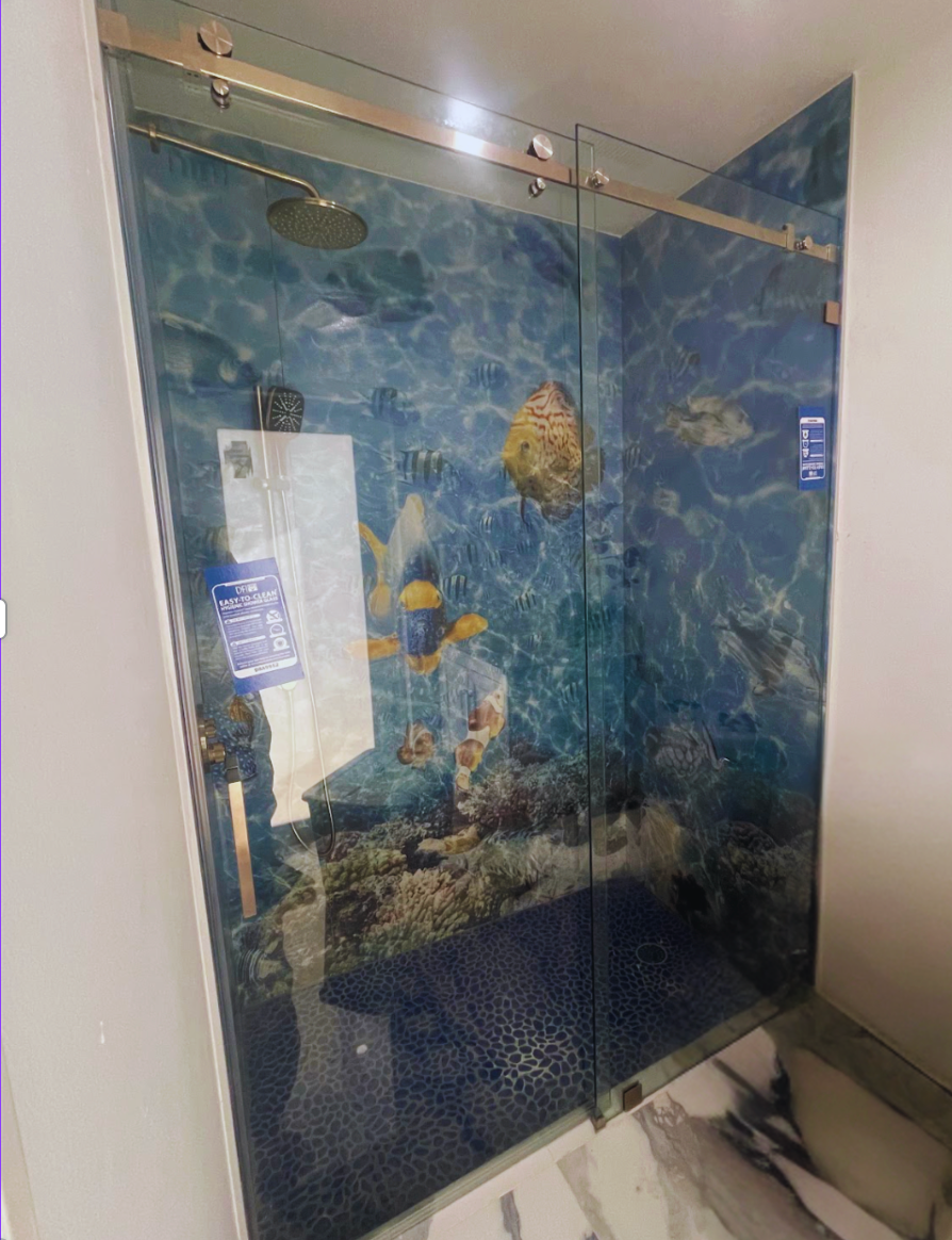 Glass shower with ocean-themed mural, featuring fish and blue water design.