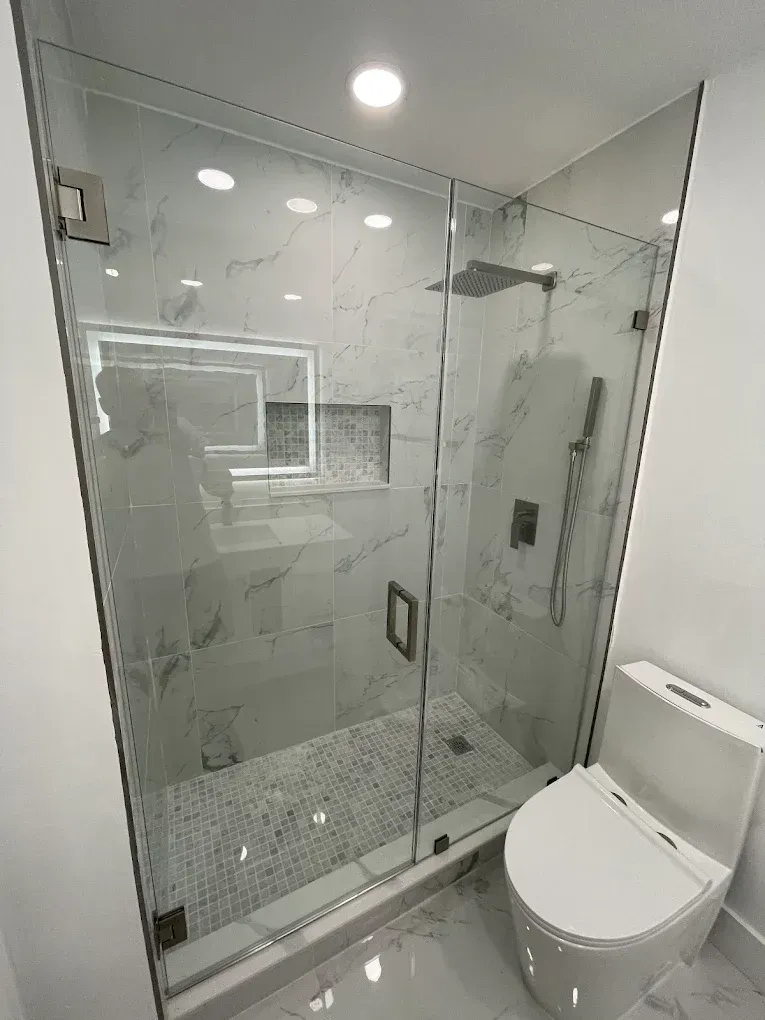 Frameless glass shower enclosure installed during a bathroom remodel project in Westchester, featuring clear tempered glass and modern hardware.