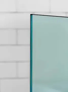 A rectangular glass panel with a thin black frame, in front of a white brick wall.