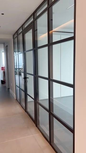 Pasillo de oficinas de vidrio con marco de aluminio negro estilo cuadrícula y puertas de vidrio enmarcadas, Miami