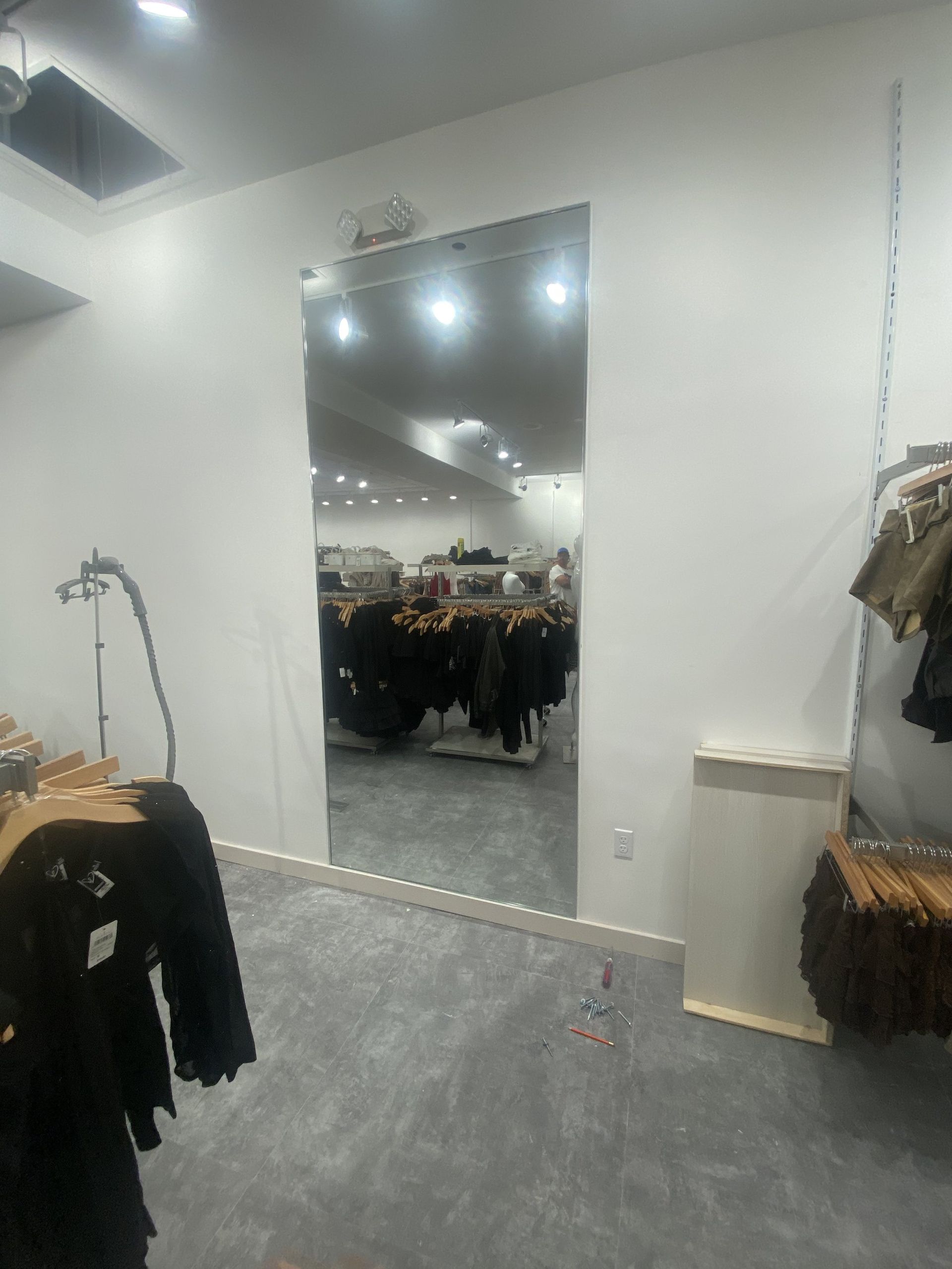 Full-length frameless wall mirror installed in a Miami clothing boutique