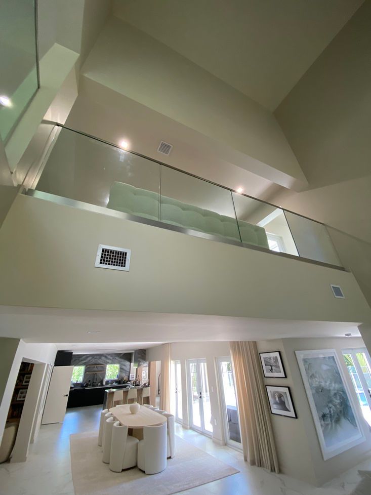 Interior view of a modern home with a balcony, open kitchen, and a dining table.