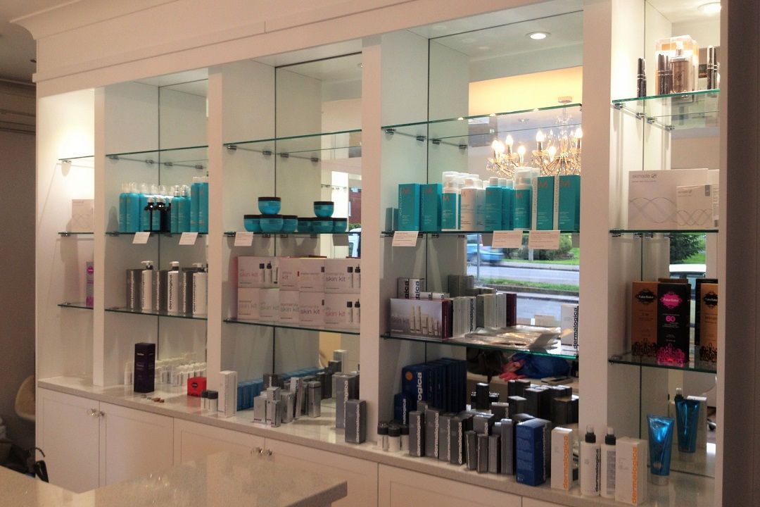 Shelves in a store display beauty products: teal, silver, white bottles, and packages.