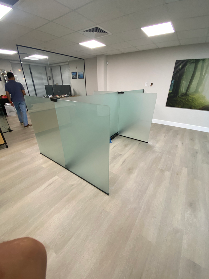 Frosted glass office dividers in a modern, light-filled space. A person stands nearby.