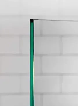 Glass panel edge against white brick wall.
