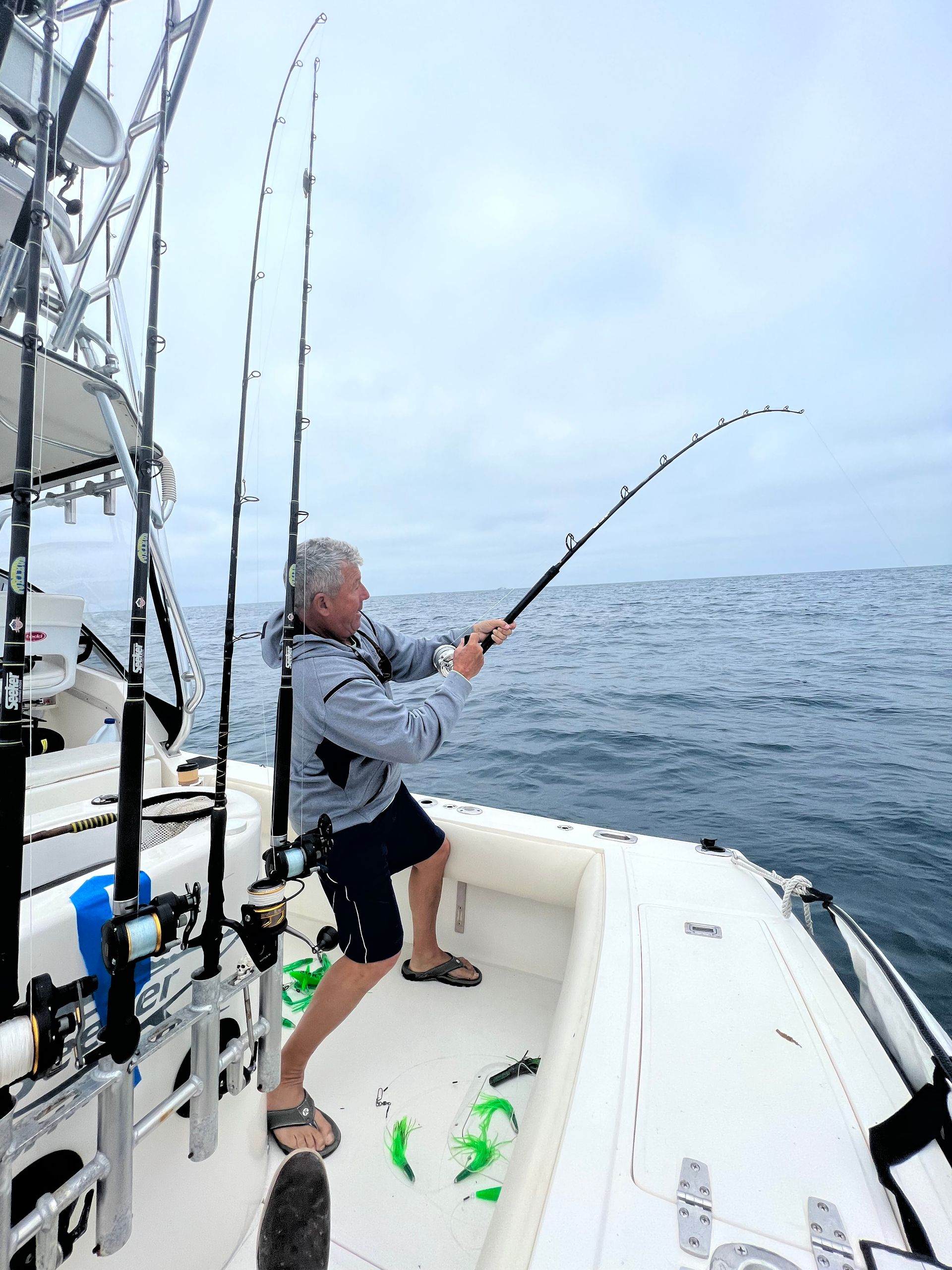 A man is fishing on a boat in the ocean